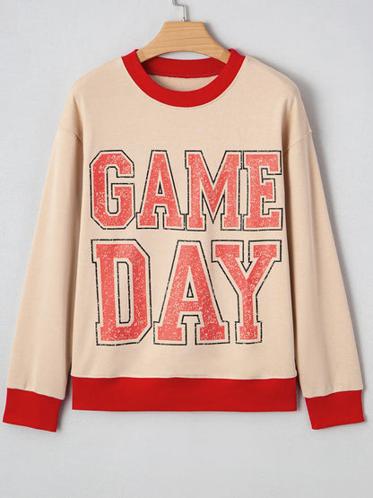 Beige sweatshirt with 'GAME DAY' text in red on a hanger against a light gray background
